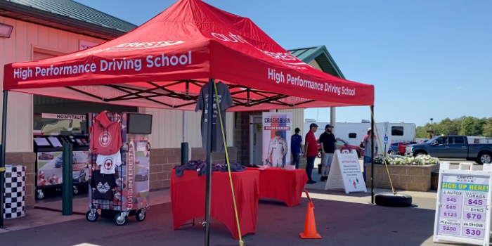 AutoInterests event setup with the High Performance Driving School canopy and merchandise